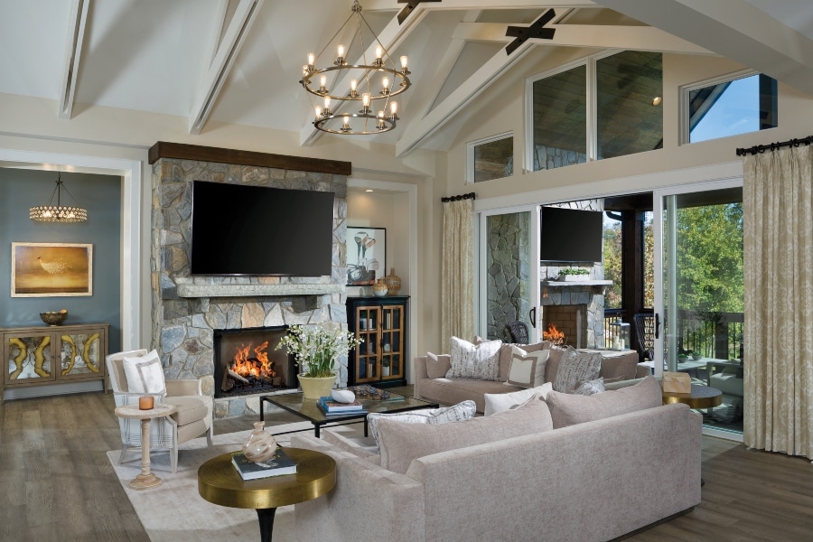 Custom Sierra Great room with white sectional, fireplace and flatscreen next to custom outdoor living area with fireplace