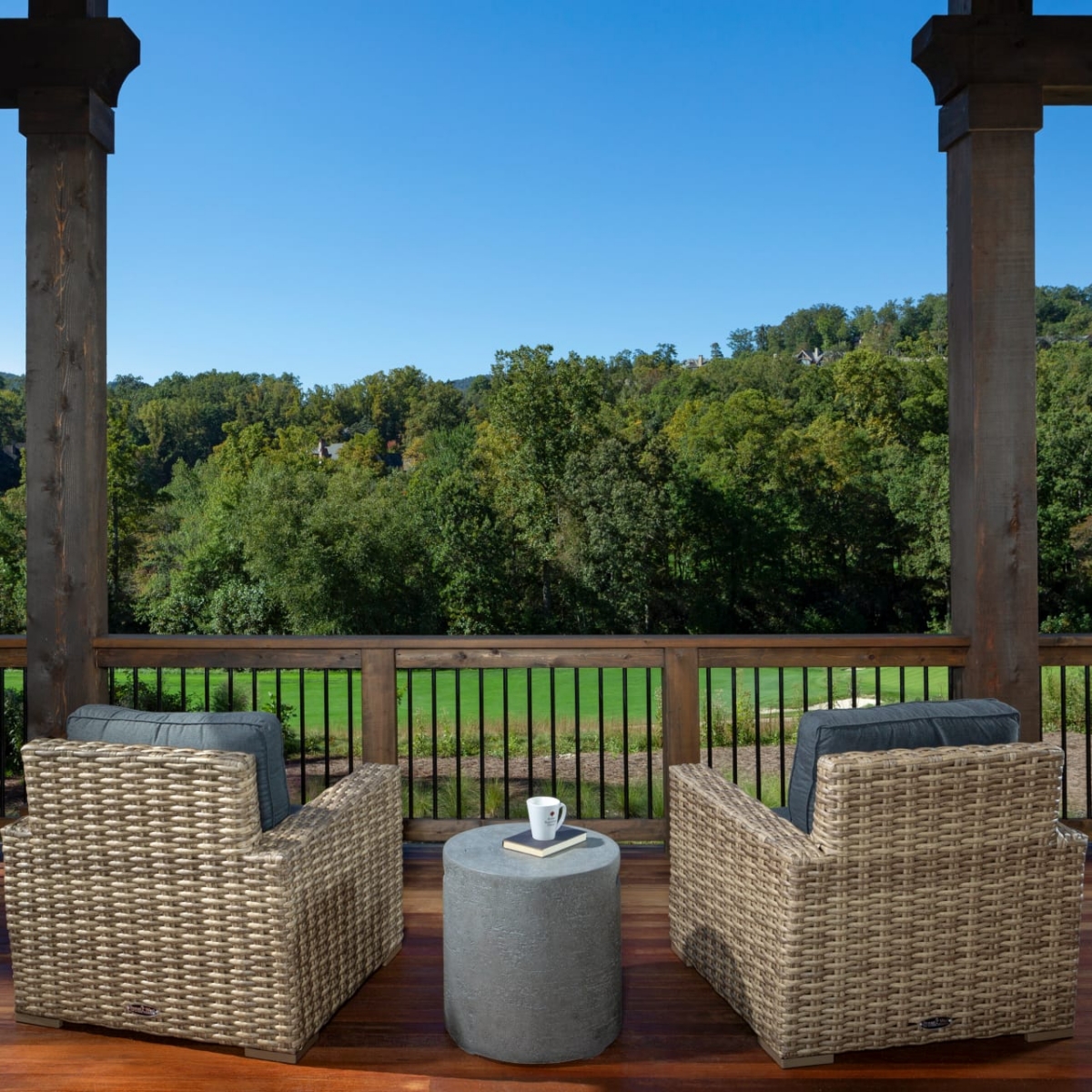 Custom Altamont outdoor living space with two lounge chairs overlooking greenery on wooden porch