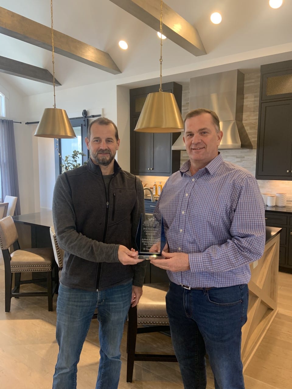 Two men shaking hands receiving homebuilder award
