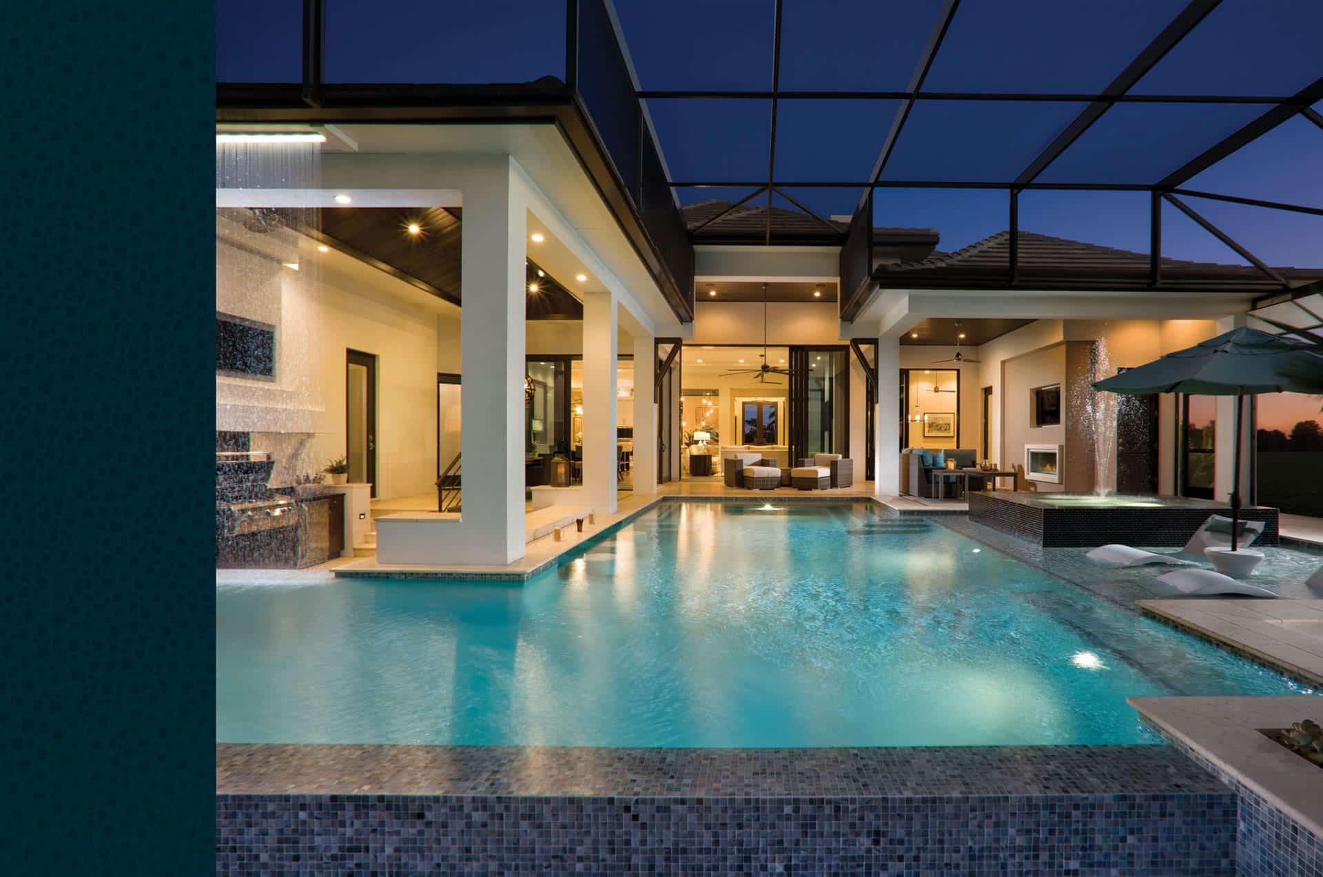 Andalucia model home pool at night with lanai and outdoor kitchen