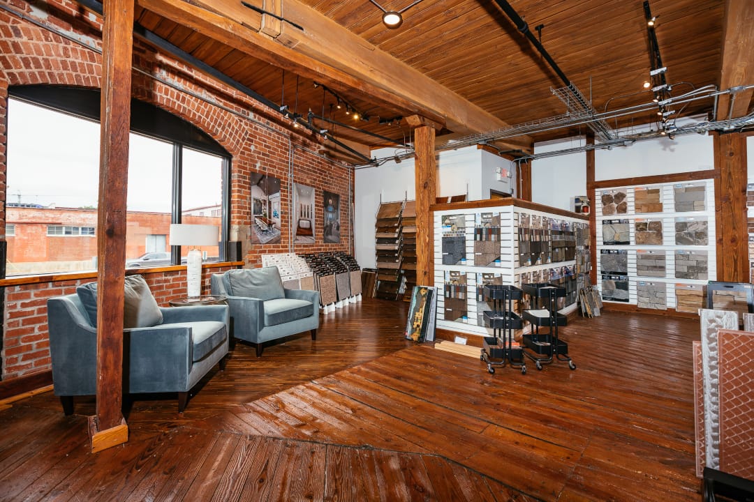 American eagle design studio with wooden floor and brick ceiling holding tile and material samples