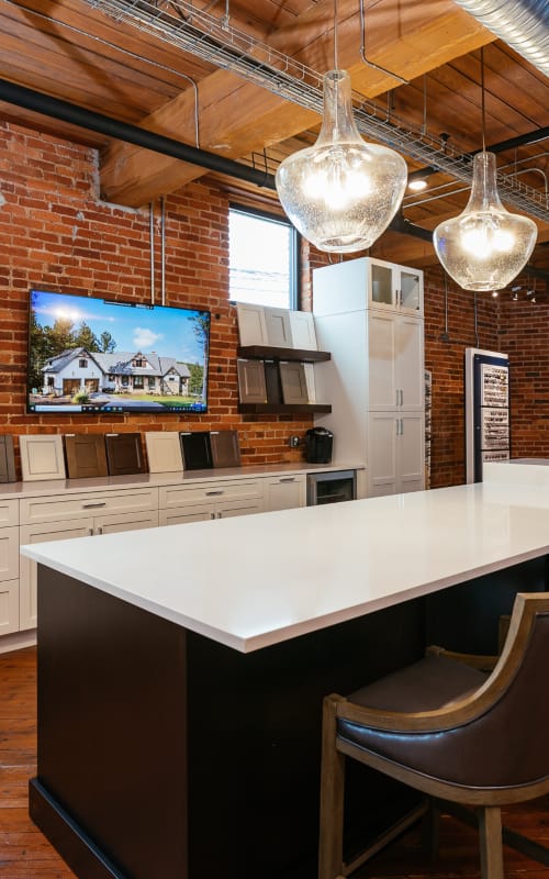 Custom design studio wood ceiling and brick wall details overlooking design samples and flatscreen