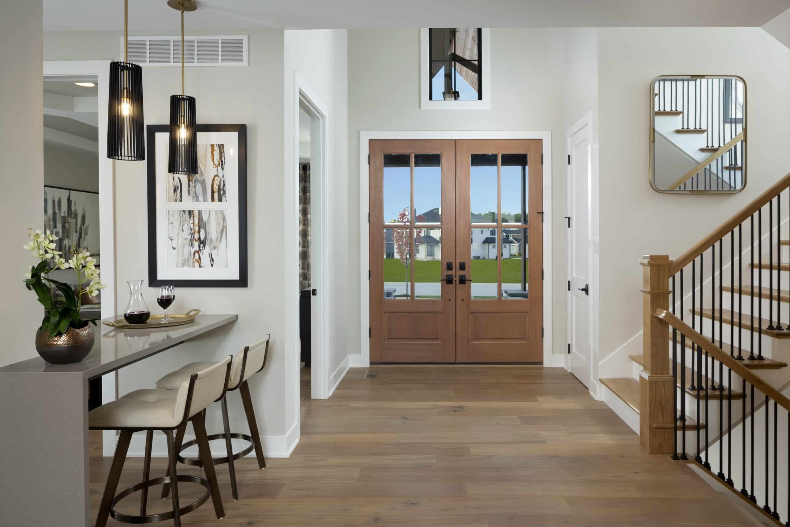 Entryway foyer with wooden doors and kitchen island chairs