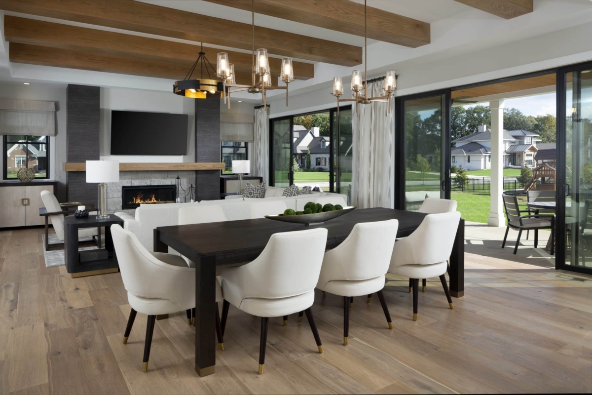 Great room table and chairs next to fireplace and floor to ceiling windows