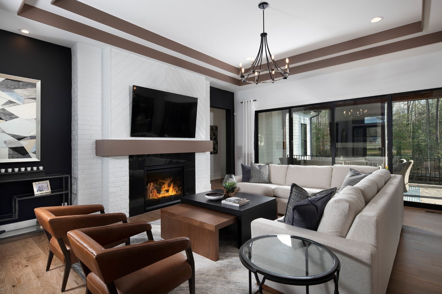 Side view of model home living room couch and seating area bv fireplace