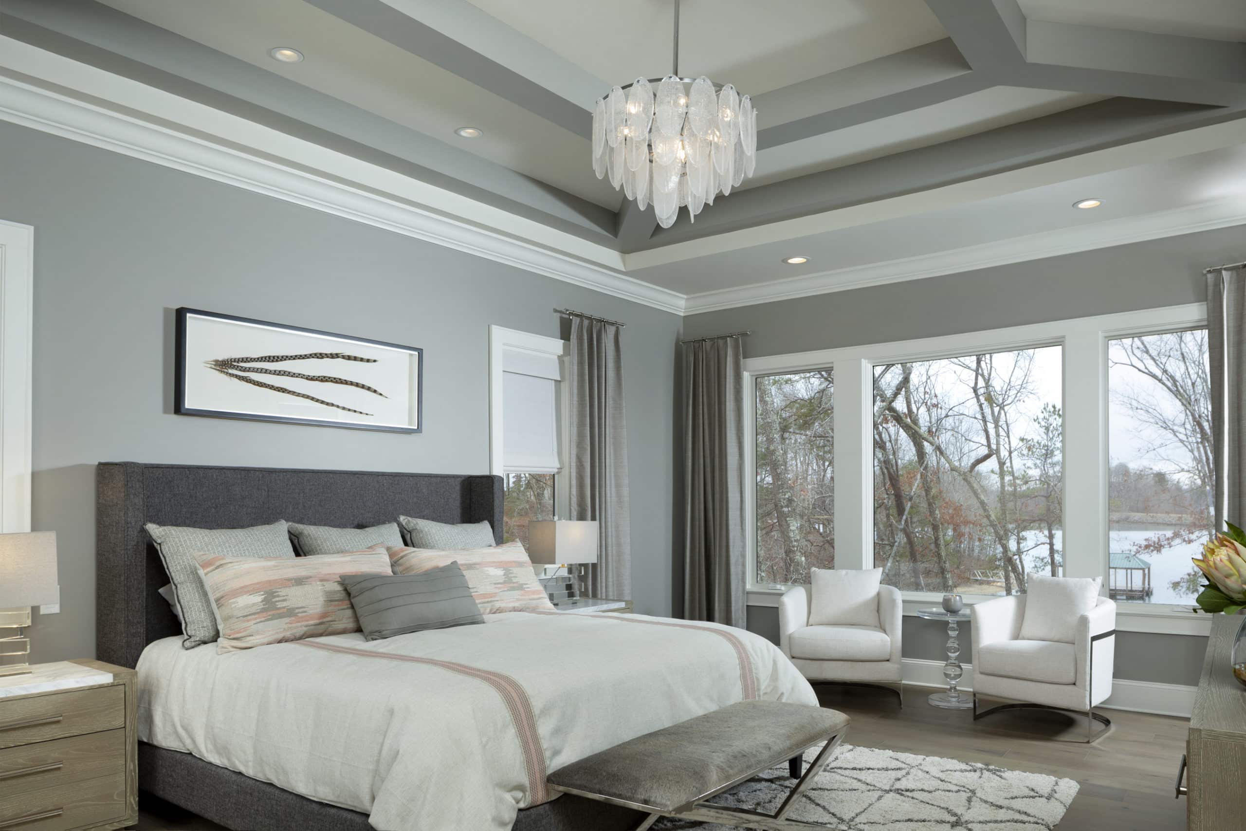 Custom Home Kennedy model owners suite with king bed, chandelier and large outdoor window